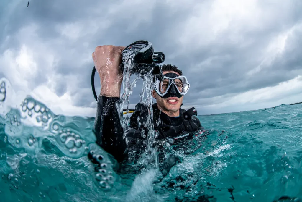Diving Beyond Limits - Deine Tauchschule in St. Pölten - Taucher an der Wasseroberfläche mit Atemregler in der Hand