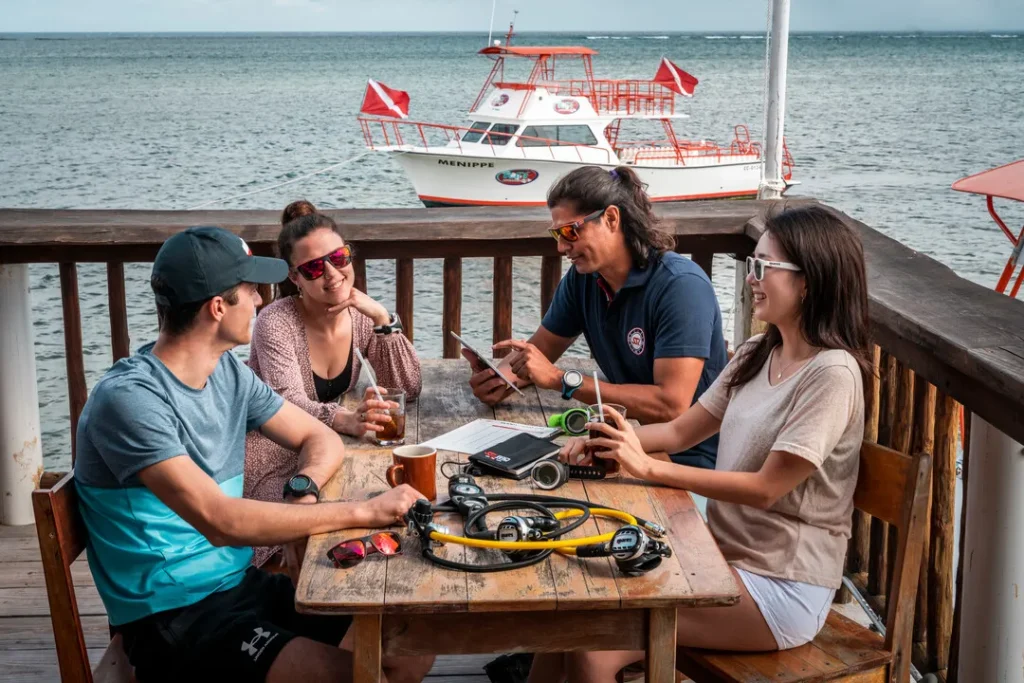 Diving Beyond Limits - Deine Tauchschule in St. Pölten - 4 Taucher sitzen am Tisch und sprechen über Atemregler